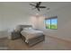 A cozy bedroom featuring a large window, ceiling fan, and two nightstands at 16832 E Hazeltine Way, Queen Creek, AZ 85142