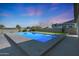 Beautiful in-ground pool offers a relaxing oasis in this backyard, set against a backdrop of vibrant sunset skies at 16832 E Hazeltine Way, Queen Creek, AZ 85142