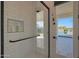 White tiled shower with a glass door, a shower head, a shelf and a grab bar, with a view of the pool at 16832 E Hazeltine Way, Queen Creek, AZ 85142