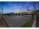 An outdoor sports court area including tennis and basketball, complemented by landscaping and neighborhood views at sunset at 16832 E Hazeltine Way, Queen Creek, AZ 85142