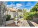 Landscaped backyard with mature plants, a charming fountain, and a paver pathway under a blue sky at 17132 N Silver Path, Surprise, AZ 85374