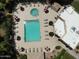 Aerial shot of community pool with lounge chairs, umbrellas, manicured landscaping, and nearby buildings at 17132 N Silver Path, Surprise, AZ 85374