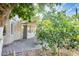 Inviting outdoor space with a covered patio, stone pavers, lush greenery, and a partial view of the home at 17132 N Silver Path, Surprise, AZ 85374