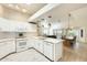 Open-concept kitchen with white cabinets, modern appliances, a counter island, and sightlines to dining and living areas at 17132 N Silver Path, Surprise, AZ 85374