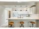 The kitchen features white cabinetry, a stylish countertop island with barstool seating, and modern pendant lighting at 17132 N Silver Path, Surprise, AZ 85374