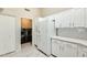 Bright kitchen showcases white cabinets, quartz countertops, modern appliances, and a convenient laundry area at 17132 N Silver Path, Surprise, AZ 85374