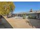 Large backyard featuring a patio area with a table and chairs, surrounded by mature trees and green shrubs at 18614 N Conestoga Dr, Sun City, AZ 85373