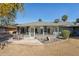 Rear exterior of home featuring a sunroom, landscaping, and patio with seating at 18614 N Conestoga Dr, Sun City, AZ 85373