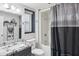 Bathroom with a shower/bathtub combo, stylish vanity, and a decorative shower curtain at 18614 N Conestoga Dr, Sun City, AZ 85373