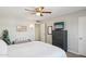 Clean bedroom with a white bed, ceiling fan, wall art, and a bench near the bed at 18614 N Conestoga Dr, Sun City, AZ 85373