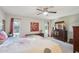 Comfortable bedroom with decorative art, dark wood furniture, ceiling fan, and natural light at 18614 N Conestoga Dr, Sun City, AZ 85373