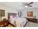 Well-lit bedroom with a wooden-framed bed, floral patterned bedding, and dark wood furniture at 18614 N Conestoga Dr, Sun City, AZ 85373