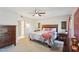 Spacious bedroom featuring a dresser, nightstands, bed with floral bedding, and access to the bathroom at 18614 N Conestoga Dr, Sun City, AZ 85373