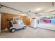 Spacious garage with a golf cart, storage, and a refrigerator at 18614 N Conestoga Dr, Sun City, AZ 85373