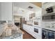 Updated kitchen features sleek white cabinetry, stainless steel appliances, and granite countertops at 18614 N Conestoga Dr, Sun City, AZ 85373