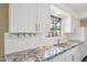Bright kitchen showcases white cabinets, granite counters, subway tile backsplash and stainless steel appliances at 18614 N Conestoga Dr, Sun City, AZ 85373