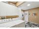 Clean laundry room with white appliances, storage cabinets, and an exterior door at 18614 N Conestoga Dr, Sun City, AZ 85373