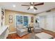 Bright living room with two armchairs, ceiling fan, and view of a plant display through the window at 18614 N Conestoga Dr, Sun City, AZ 85373