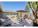 A cozy patio area with an umbrella-covered dining table, cushioned seating, and desert plant accents at 18614 N Conestoga Dr, Sun City, AZ 85373