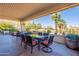 Outdoor dining area featuring a glass-top table with seating and beautiful views of the landscaped backyard at 18716 E White Wing Dr, Rio Verde, AZ 85263