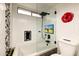 Modern bathroom featuring a tub with glass enclosure, a rain shower head, and a built-in TV at 1880 E Morten Ave # 130, Phoenix, AZ 85020