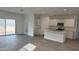 Bright, open kitchen and living area with white cabinets, island, stainless appliances, and sliding glass doors at 18878 E Bruno Dr, Gold Canyon, AZ 85118