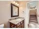 Cozy powder room features granite counters, wood cabinetry, and a decorative framed mirror at 19226 N Cave Creek Rd # 109, Phoenix, AZ 85024