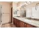 Bathroom featuring double sinks, granite countertops, wood cabinets, and a large mirror at 19226 N Cave Creek Rd # 109, Phoenix, AZ 85024