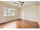 Bright bedroom featuring wood floors, neutral walls, a ceiling fan, and natural light from large window at 19226 N Cave Creek Rd # 109, Phoenix, AZ 85024