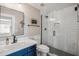 Updated bathroom features a glass enclosed shower with white subway tile and a blue vanity with quartz countertop at 19240 N 90Th Pl, Scottsdale, AZ 85255
