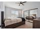 Modern bedroom featuring a bed, a ceiling fan, and sliding mirrored closet doors at 19240 N 90Th Pl, Scottsdale, AZ 85255