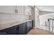 Hallway with built-in cabinets features white uppers, navy lowers, and a marble countertop at 19240 N 90Th Pl, Scottsdale, AZ 85255