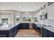 Modern kitchen with dark blue lower cabinets, white upper cabinets, stainless steel appliances and countertop space at 19240 N 90Th Pl, Scottsdale, AZ 85255