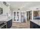 Open-concept kitchen with white cabinets, an island with seating, pantry with glass doors, and stainless appliances at 19240 N 90Th Pl, Scottsdale, AZ 85255