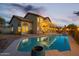Beautiful backyard swimming pool reflects the home's lighted back exterior and upstairs balcony at 19240 N 90Th Pl, Scottsdale, AZ 85255