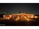 Night view of a mid-century modern home with a well-lit walkway and desert landscaping at 2055 W Windsor Ave, Phoenix, AZ 85009