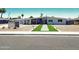 Daytime view of a mid-century modern home with desert landscaping and a vibrant orange front door at 2055 W Windsor Ave, Phoenix, AZ 85009