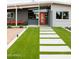 Close-up of the front entrance with a modern walkway, artificial turf, and bright orange door at 2055 W Windsor Ave, Phoenix, AZ 85009