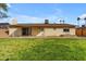 A green grass backyard features a patio and solar panels on the roof at 2447 E La Jolla Dr, Tempe, AZ 85282