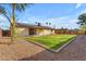 The green grass backyard features a patio and solar panels on the roof at 2447 E La Jolla Dr, Tempe, AZ 85282