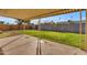 A covered patio overlooks the green grass lawn in the fenced backyard at 2447 E La Jolla Dr, Tempe, AZ 85282