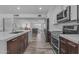 Open concept kitchen with stainless steel appliances, quartz countertops, and seamless flow into the living room at 2447 E La Jolla Dr, Tempe, AZ 85282