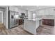 Bright kitchen features white cabinetry, stainless steel appliances, and spacious island with quartz countertops at 2447 E La Jolla Dr, Tempe, AZ 85282