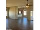 Spacious open floor plan with wood-look tile flooring, ceiling fans, and an adjoining kitchen area with breakfast bar at 24836 W Montgomery W Rd, Wittmann, AZ 85361