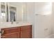 Bathroom featuring sink with wood cabinets, and a framed mirror at 25610 N 144Th Ln, Surprise, AZ 85387