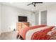 Well-lit bedroom featuring carpet flooring, ceiling fan, and natural light from a large window at 25610 N 144Th Ln, Surprise, AZ 85387