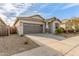 Attractive single-Gathering home showcasing desert landscaping, concrete driveway, and a covered entryway at 25610 N 144Th Ln, Surprise, AZ 85387