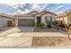 Charming single-story home featuring a well-manicured front yard, a two-car garage, and a welcoming entrance at 25610 N 144Th Ln, Surprise, AZ 85387