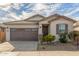 Well-maintained one-story house featuring desert landscaping, a two-car garage, and a covered front entryway at 25610 N 144Th Ln, Surprise, AZ 85387