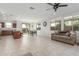 Open-concept living area with tile flooring, a ceiling fan, and plentiful natural light from large windows at 25610 N 144Th Ln, Surprise, AZ 85387